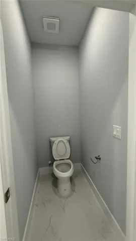 Bathroom featuring baseboards and marble look tiles