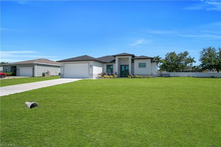 Contemporary stucco exterior with a dark shingle roof and an expansive front lawn