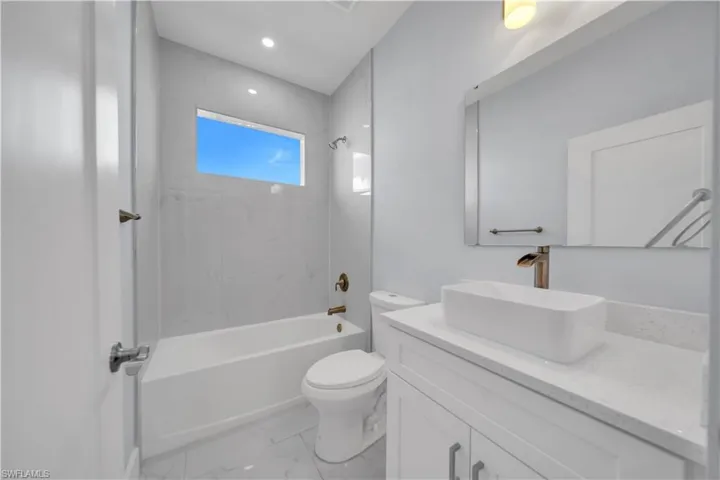 Bathroom featuring a white vanity with a rectangular vessel sink, a bronze-finish faucet, and a large wall-mounted mirror