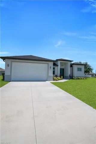 Modern facade featuring a two-car garage, concrete driveway, and covered entry