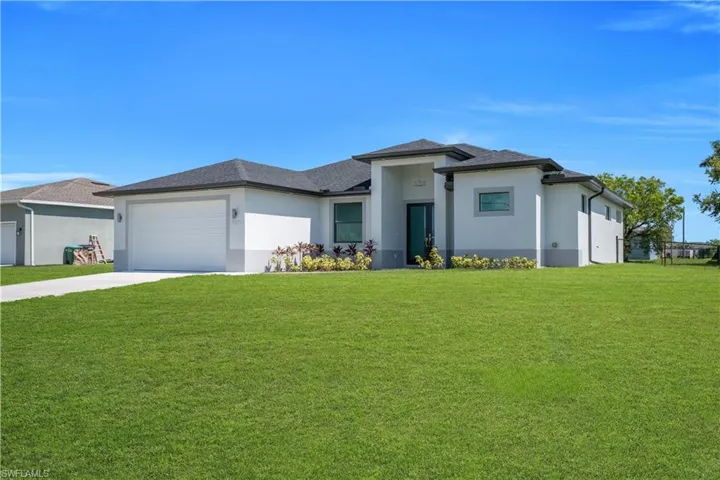 Contemporary stucco exterior with a dark shingle roof, two-tone facade, and mature landscaping