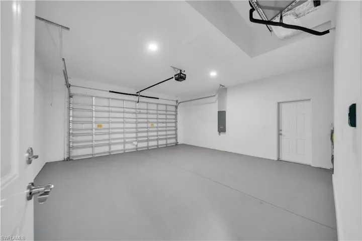 Two-car garage featuring a painted concrete floor and recessed lighting