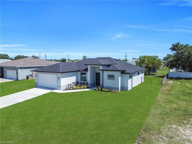 Contemporary single-story residence featuring a dark shingle roof, white stucco exterior, and a two-car garage