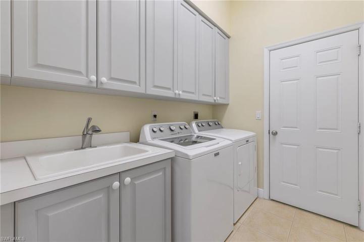 Laundry area with lots of cabinets and a mop sink.