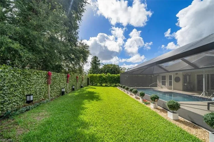 View of yard with glass enclosure and a fenced in pool