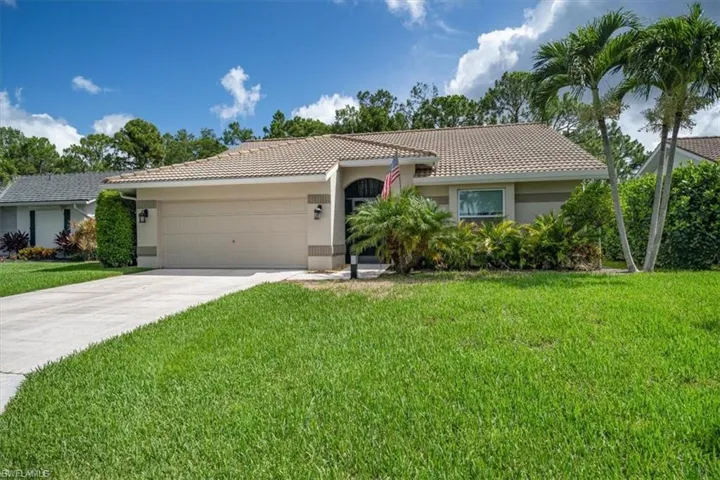 View of front of property featuring a garage and a front yard