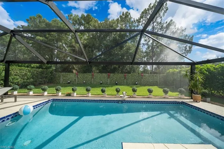 View of swimming pool featuring glass enclosure