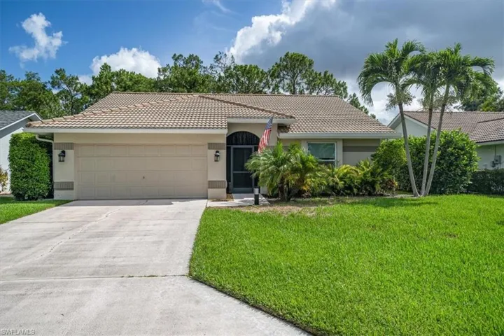 View of front of house featuring a garage and a front yard