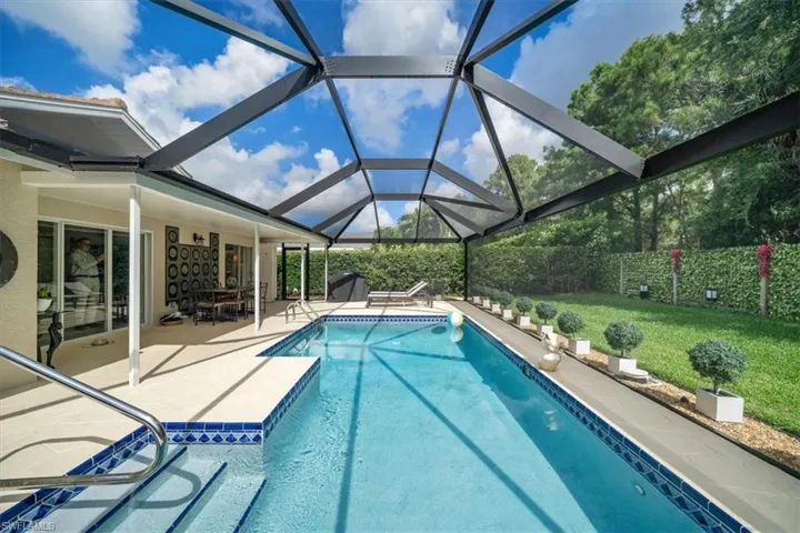View of pool featuring a patio, a lanai, and a yard