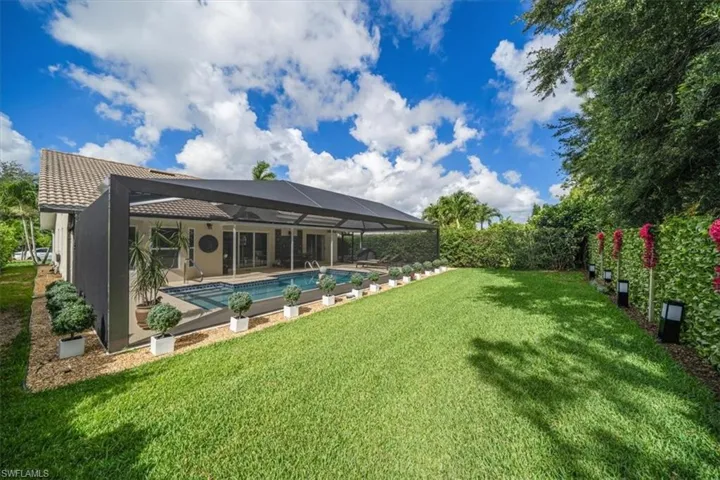 View of yard with a lanai, a patio area, and a fenced in pool