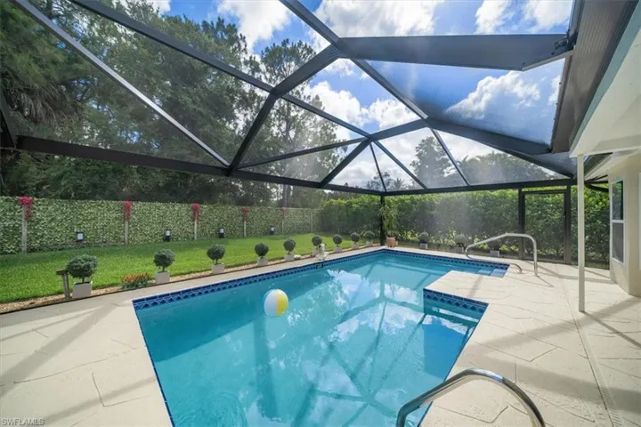 View of swimming pool with a patio and glass enclosure