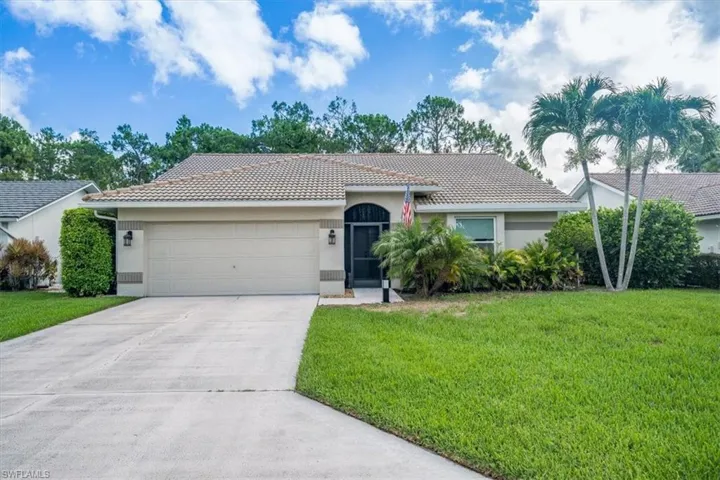 Single story home featuring a garage and a front lawn