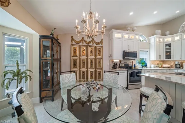 Dining space with sink, an inviting chandelier, and light tile floors