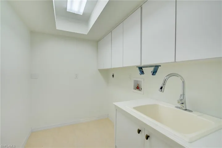 Laundry room featuring washer hookup, sink, cabinets, and electric dryer hookup