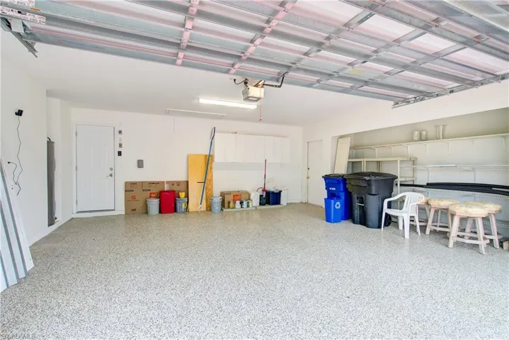 Garage featuring water heater and a garage door opener