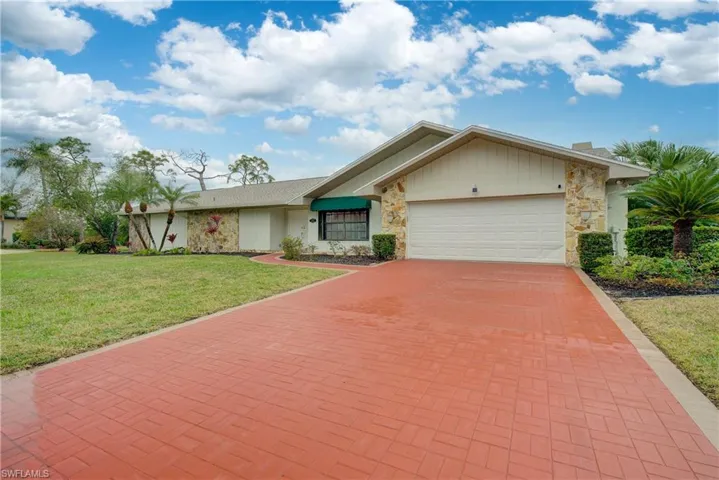 Single story home with a front yard and a garage