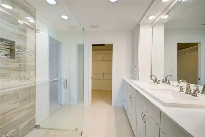 Bathroom with vanity, a shower with door, and tile patterned floors
