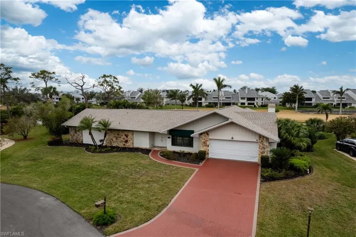 View of front of property featuring a front yard and a garage