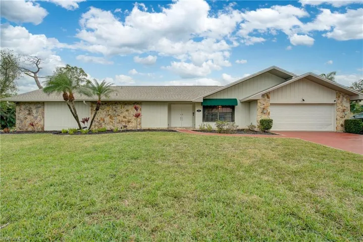 Ranch-style home with a front lawn and a garage