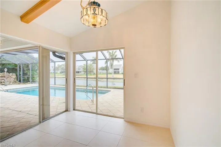 Entryway featuring vaulted ceiling with beams, light tile patterned floors, and plenty of natural light