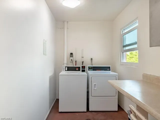 Shared laundry featuring concrete floors and washing machine and clothes dryer