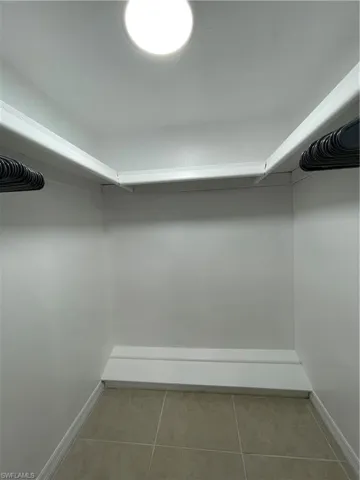 Walk in closet with light tile patterned floors
