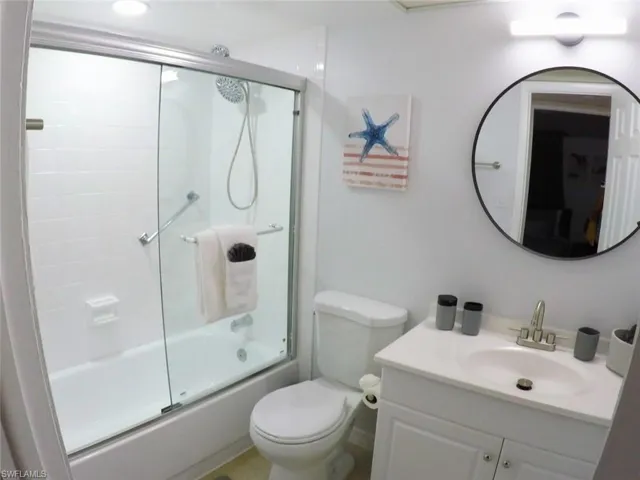 Full bath with vanity and shower / bath combination with glass door