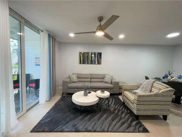 Living area with light tile patterned floors, recessed lighting, expansive windows, and ceiling fan