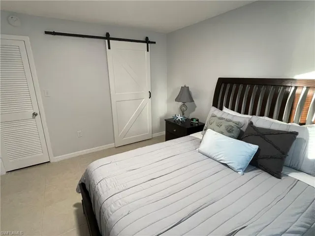 Bedroom featuring a barn door and light tile patterned floors