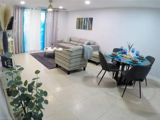 Living room with light tile patterned flooring and recessed lighting