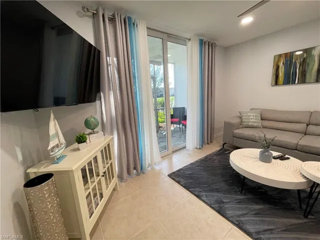 Living area with light tile patterned flooring and recessed lighting