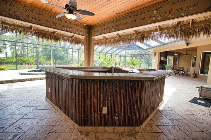View of patio with a hot tub, a lanai, and ceiling fan