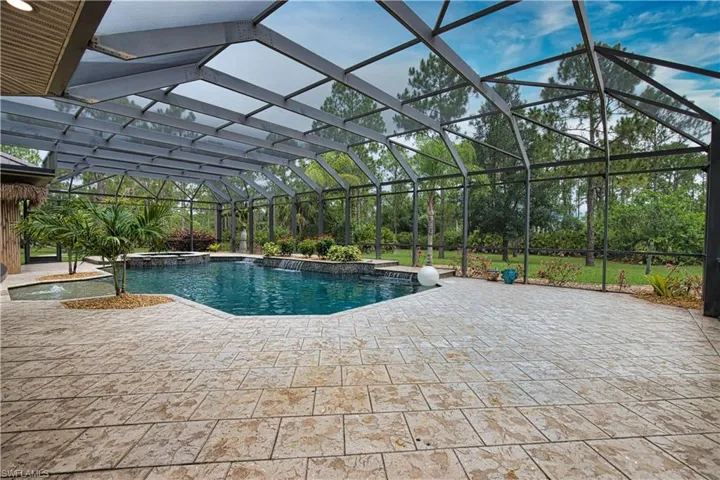 View of swimming pool featuring a patio and glass enclosure