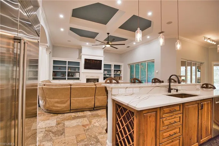 Kitchen featuring sink, pendant lighting, light tile patterned floors, ceiling fan, and coffered ceiling
