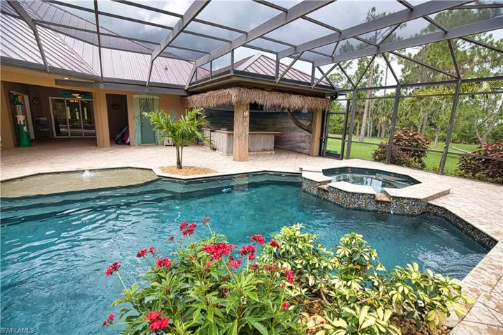 View of pool with a patio, an in ground hot tub, and glass enclosure