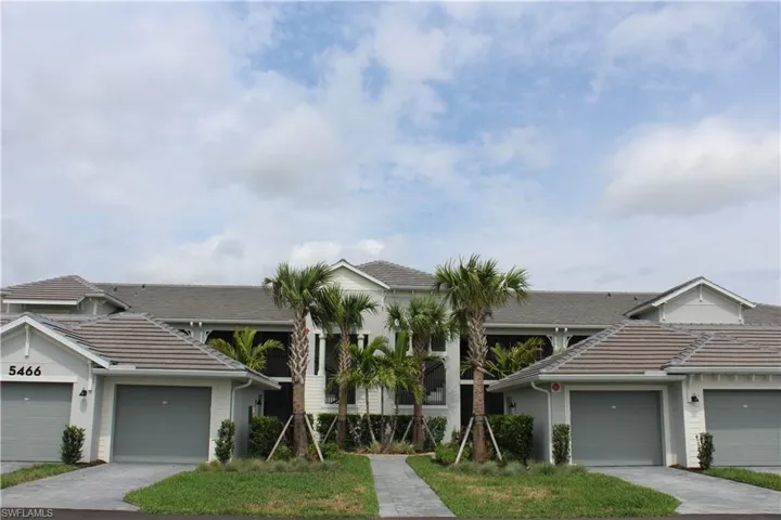 View of front of house with a tile roof, stucco siding, driveway, and an attached garage