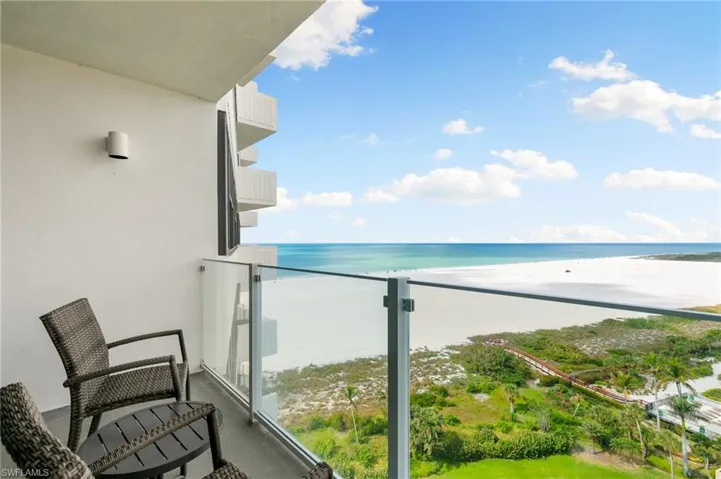 Balcony featuring a water view and a view of the beach
