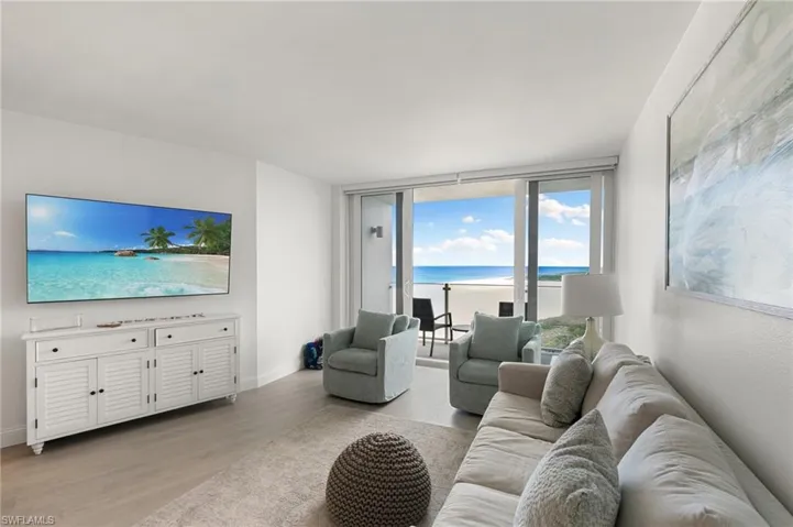 Living area with a water view, light wood-style flooring, and baseboards