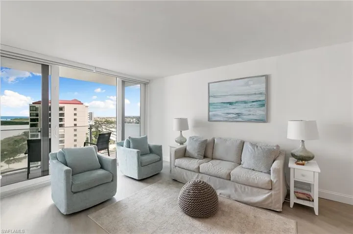 Living room with floor to ceiling windows, baseboards, and wood finished floors