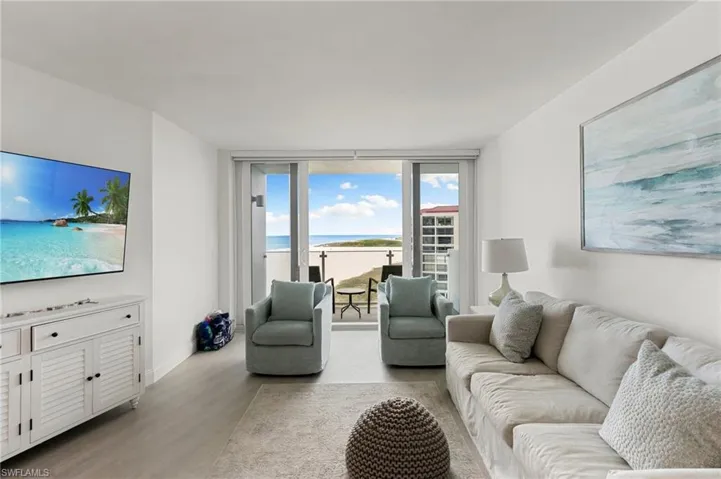 Living area featuring baseboards, a wall of windows, and wood finished floors