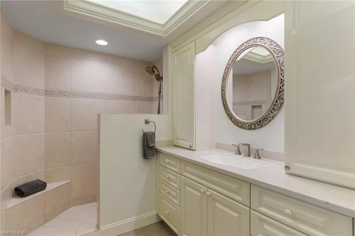 Bathroom featuring a walk in shower, vanity, and recessed lighting