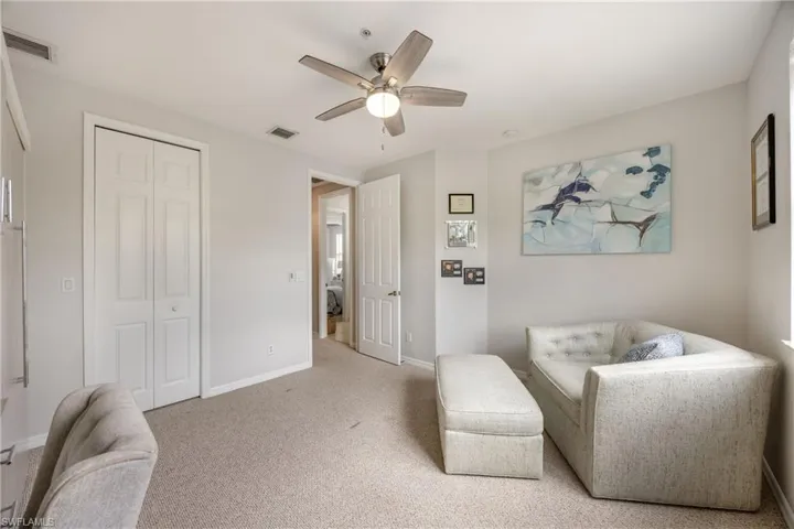 Living area with a ceiling fan and carpet floors