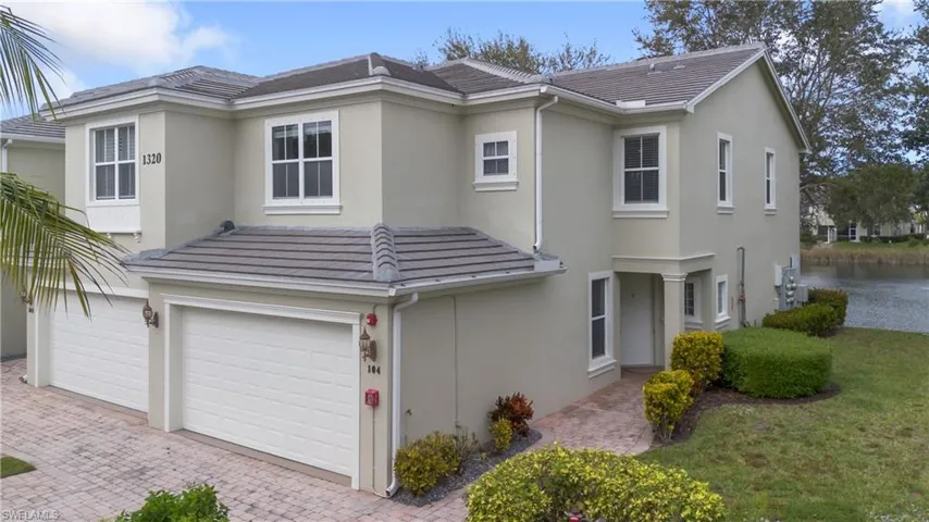Contemporary-style house with stucco siding, an attached garage, decorative driveway, and a tiled roof