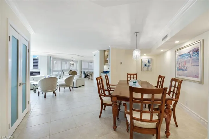 Dining room featuring an inviting chandelier, ornamental molding, and light tile patterned flooring