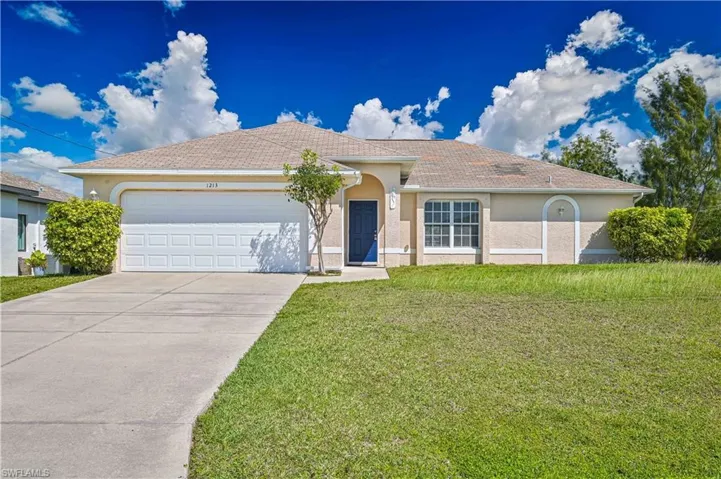 Ranch-style home featuring stucco siding, an attached garage, concrete driveway, and a front yard