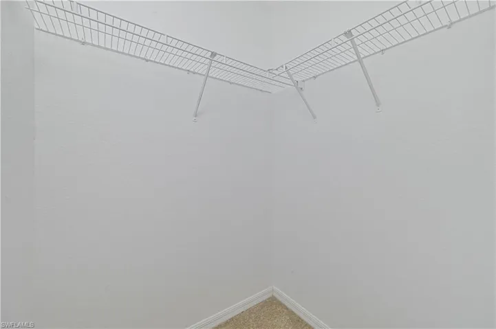 Walk in closet featuring light carpet