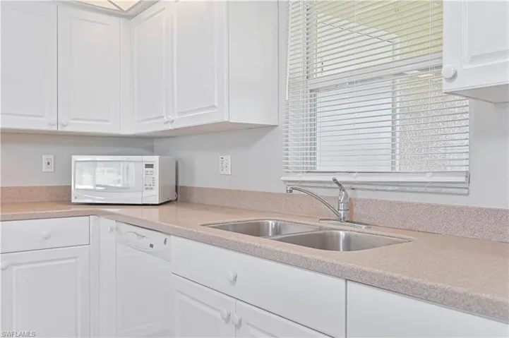Kitchen featuring white cabinets and white appliances