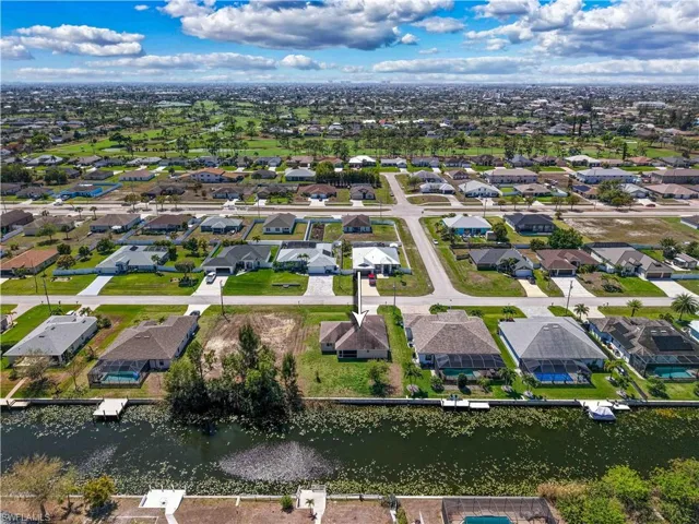 Aerial view of property and surrounding area with nearby suburban area and a nearby body of water