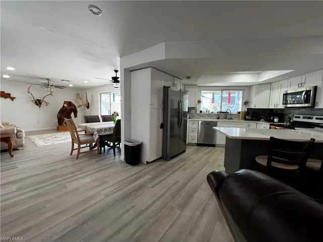Kitchen featuring appliances with stainless steel finishes, decorative backsplash, kitchen peninsula, and picture window