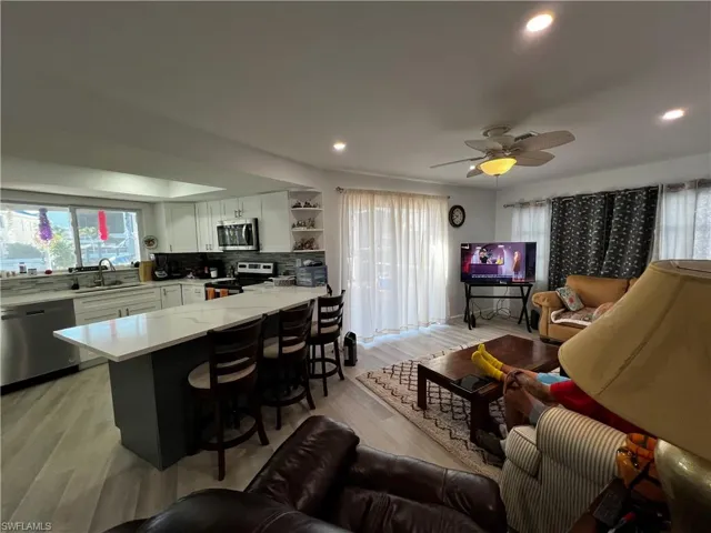 Living room #2 with ceiling fan, a healthy amount of sunlight